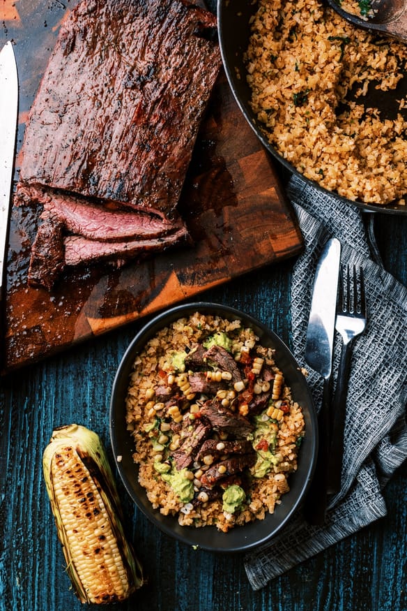Cilantro Lime Cauliflower rice topped with fresh guacamole, and perfectly seasoned flank steak for a great low carb lunch or dinner!