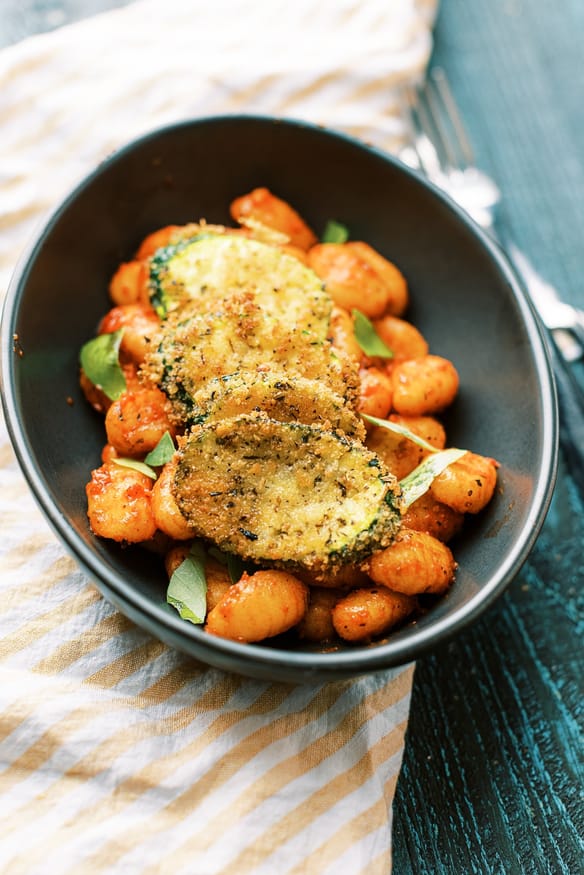 Panko breaded fried zucchini is a great way to inject some veggies into pasta night. Italian seasoned and lightly fried then topped on some gnocchi is perfect!