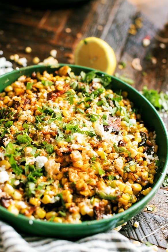 Hatch Chile and Bacon Esquites cooked on a blackstone flattop grill, loaded with cheese and absolutely delicious. Perfect as a game day snack, a topping for tacos, or just an amazing side dish to serve for dinner!