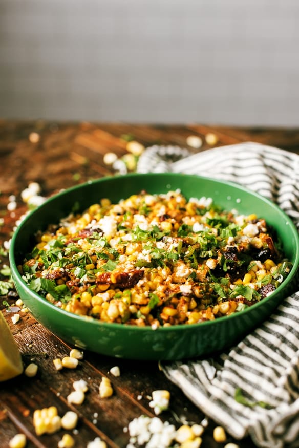 Hatch Chile and Bacon Esquites cooked on a blackstone flattop grill, loaded with cheese and absolutely delicious. Perfect as a game day snack, a topping for tacos, or just an amazing side dish to serve for dinner! 