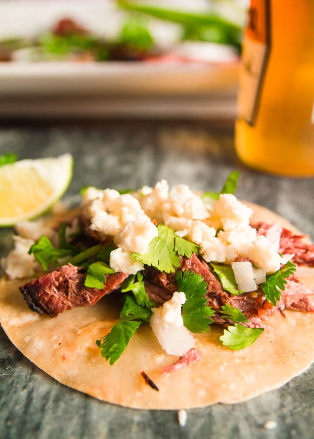 This carne asada beer marinade recipe uses a light beer and fresh citrus ingredients, with some heat and smokiness using cayenne jalapeno and smoked paprika.