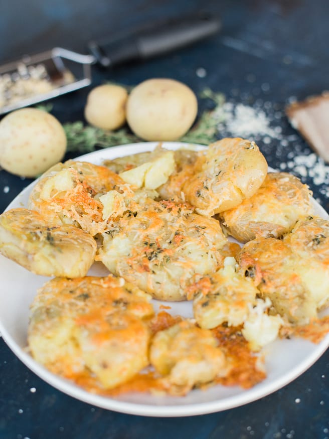 Smashed Potatoes smothered in a herb garlic butter with parmesan and cheddar cheese. Perfect comfort food side and is the best smashed potato recipe ever! 