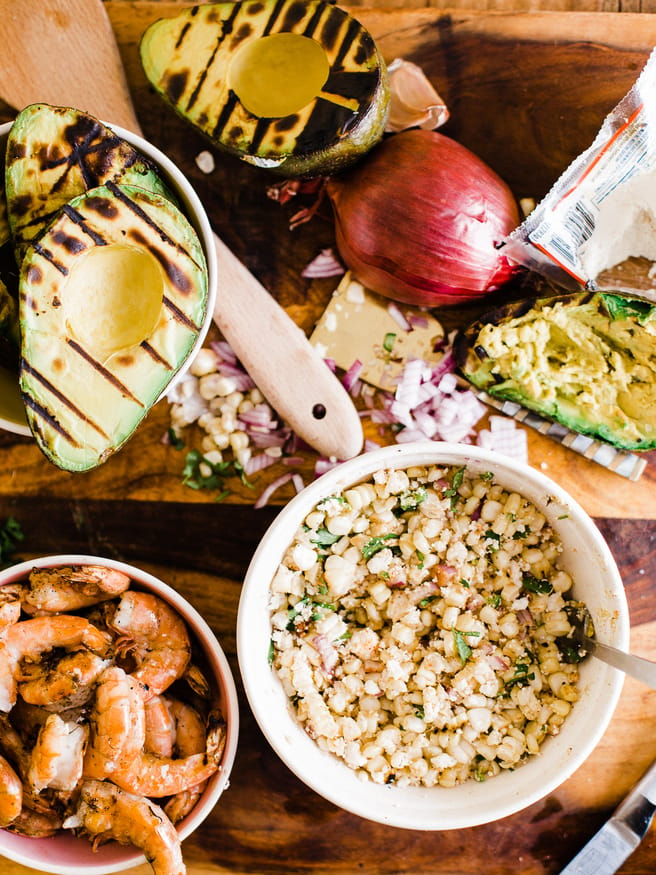 Grilled Avocado Bowl with Elote cut off the cob and topped with some grilled shrimp. This makes a great side dish or light lunch! 