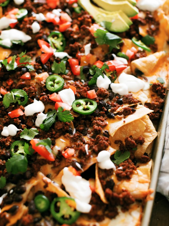 Taco Night Sheet Pan Nachos are a great way to put a spin on taco night. Taco seasoned ground beef and all your favorite taco toppings on sheet pan nachos.