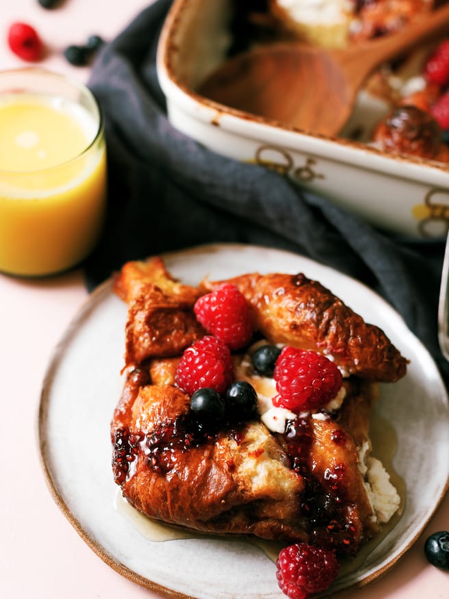 This cream cheese croissant french toast bake is topped with raspberry jam and served with fresh fruit. Can be prepped overnight and bakes in under an hour!