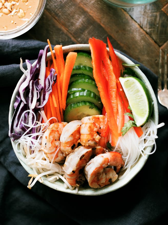 This spring roll bowl has grilled shrimp, rice stick noodles, and fresh veggies topped with a peanut sauce. Much easier to make than actual spring rolls!
