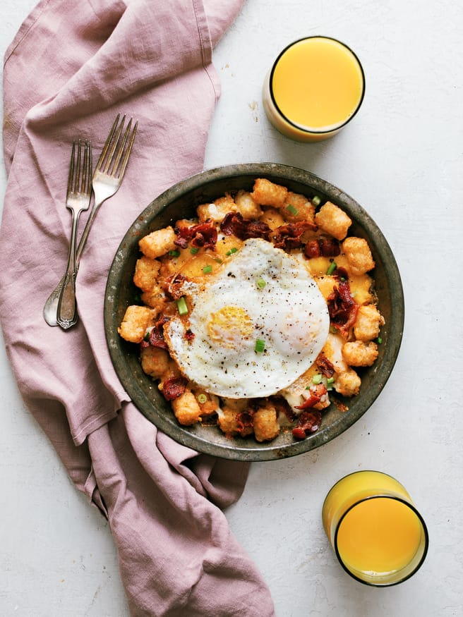 Tater Tots loaded up with bacon, cheese and green onion, then topped with a couple fried eggs. Great breakfast for dinner idea!
