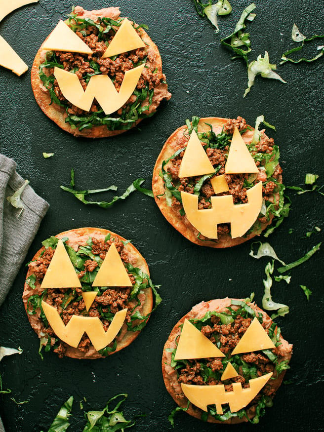  Jack O lantern tostadas are  topped  with beans, taco-seasoned ground beef and cheese cut out into fun jack-o-lantern shapes. Great halloween night dinner!