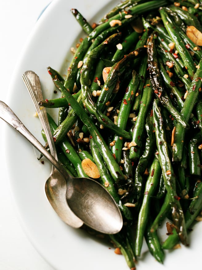 These blistered green beans are fried lightly in oil until blistered, then tossed in a spicy Asian cuisine inspired sauce that is out of this world!