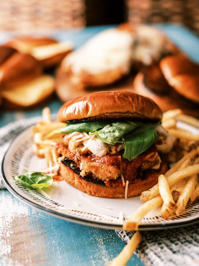 Chicken Parmesan Sandwiches in the theme of a burger. They're a delicious way to change up your chicken Parmesan and so fun to eat!
