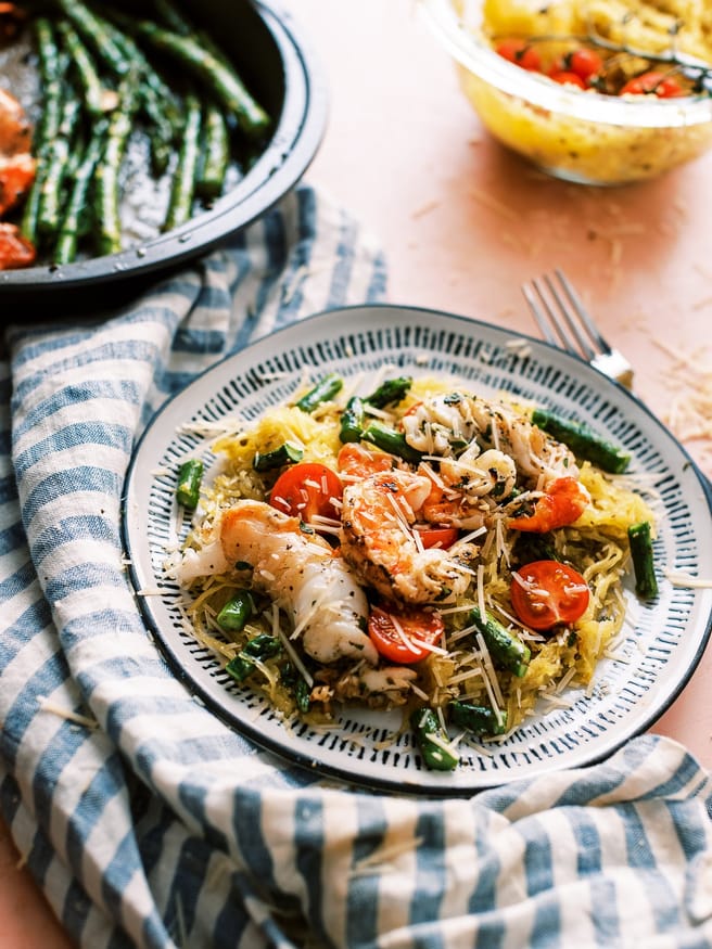 I'm going all out for this recipe and dressing up this spaghetti squash in pesto and topping with some grilled shrimp and asparagus!