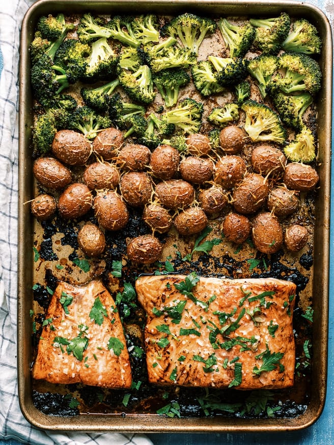 Easy weeknight Sheet Pan recipe with salmon glazed with a lemony honey butter garlic sauce served with baby red potatoes and broccoli. It's easy and a well rounded meal!