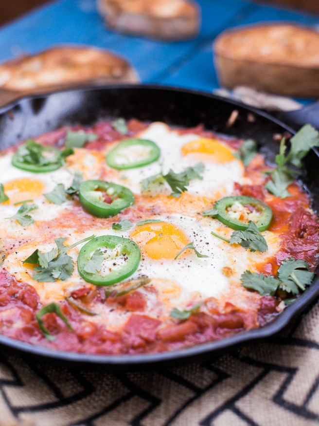 Eggs In Hell with some spice! Jalapeños added to diced tomatoes onions and garlic, topped with cheese and eggs. This is the ultimate comfort food! 