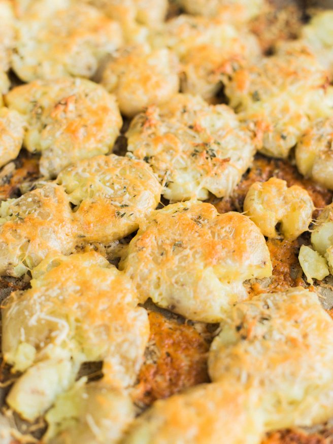 Smashed Potatoes smothered in a herb garlic butter with parmesan and cheddar cheese. Perfect comfort food side and is the best smashed potato recipe ever! 