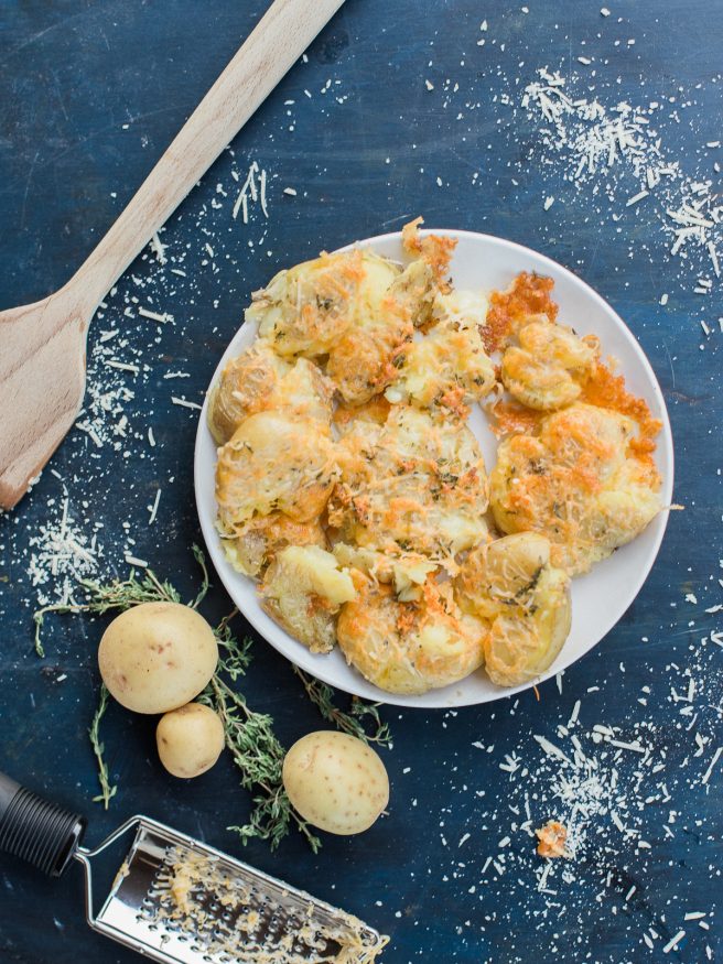 Smashed Potatoes smothered in a herb garlic butter with parmesan and cheddar cheese. Perfect comfort food side and is the best smashed potato recipe ever! 