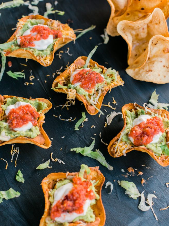 Homemade tostada bowl filled with 7 layer bean dip fillings making this a perfect weeknight meal or even for game day!