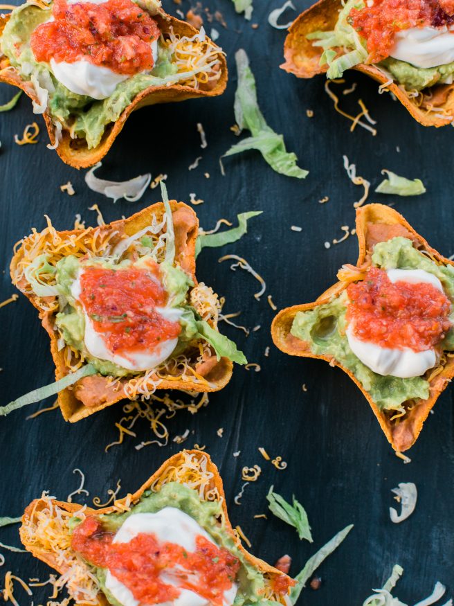 Homemade tostada bowl filled with 7 layer bean dip fillings making this a perfect weeknight meal or even for game day!