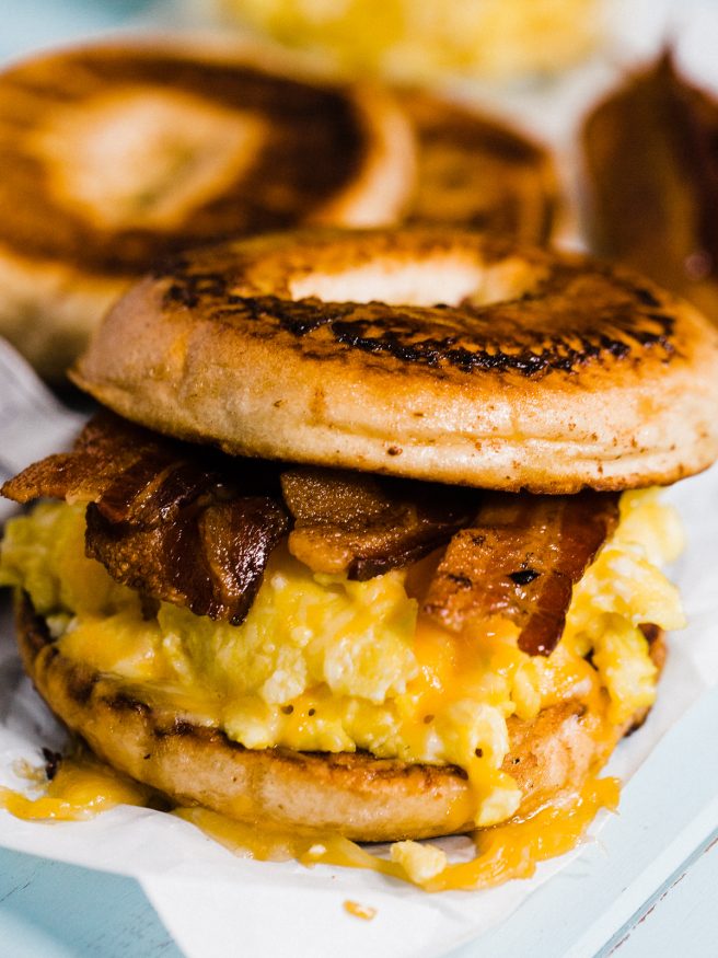 French Toast Bagel topped with eggs, cheese and smokey bacon, making for a sweet and savory breakfast sandwich everyone is going to love! 