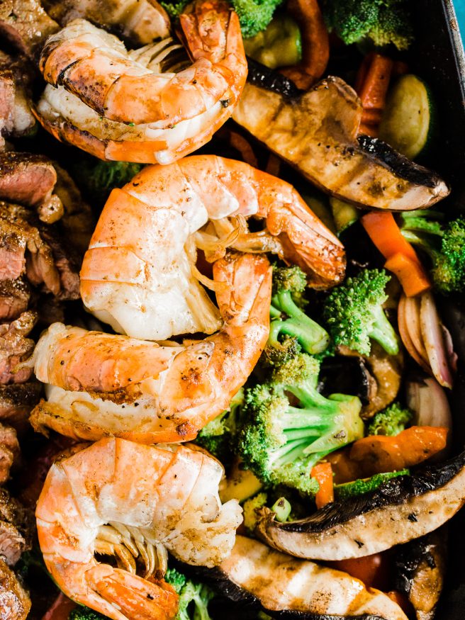 A Surf n' Turf Paleo bowl with Steak and Shrimp, over bell peppers, shallots, portabella mushroom, zucchini with a savory seasoning.