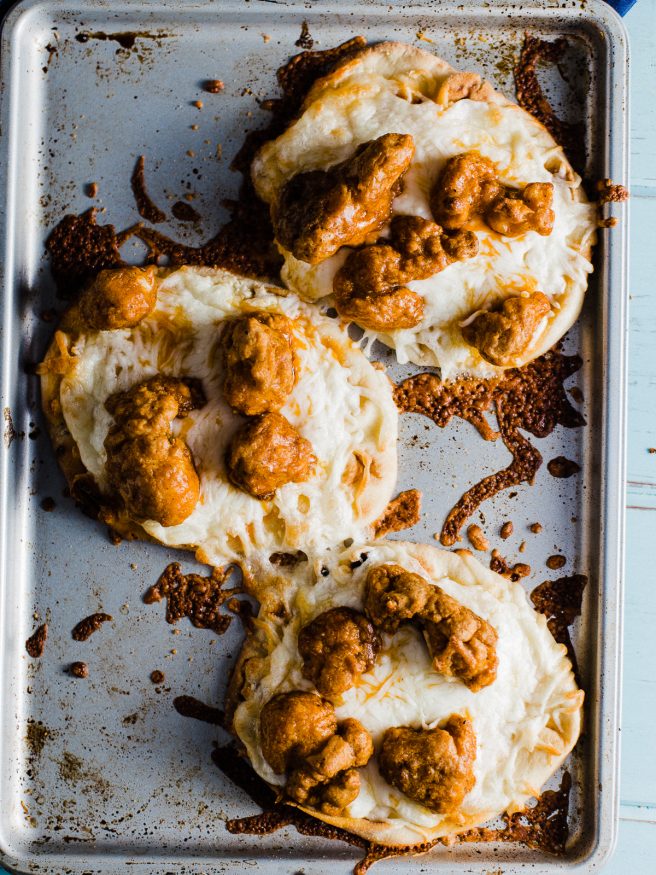 An buffalo chicken flatbread pizza, that is topped with a celery and carrot bleu cheese slaw. Easy dinner night and makes a perfect game day lunch!