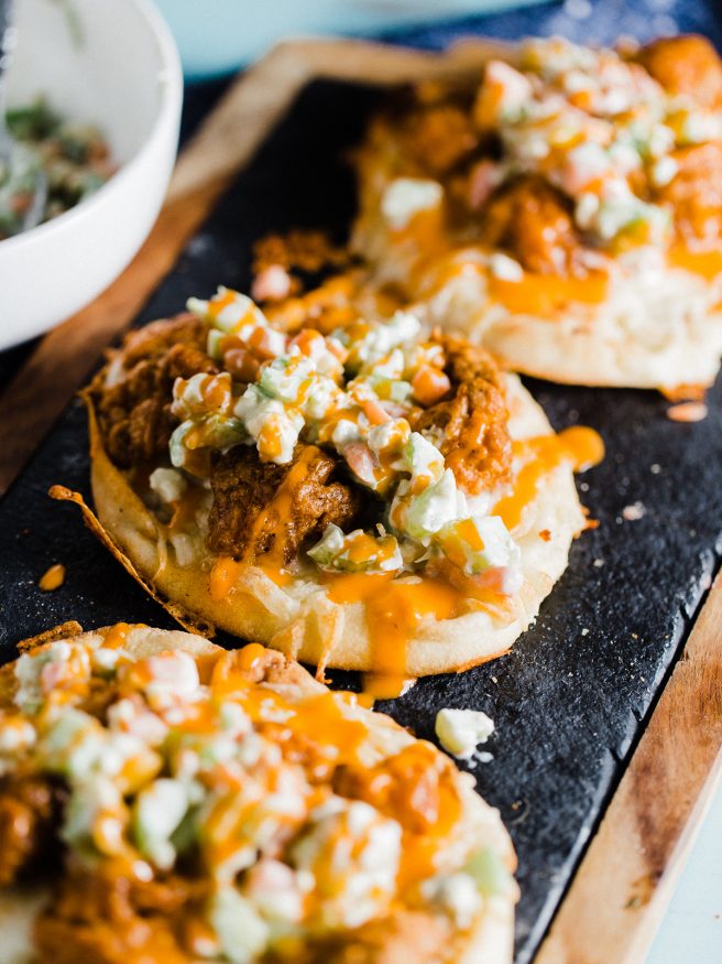 An buffalo chicken flatbread pizza, that is topped with a celery and carrot bleu cheese slaw. Easy dinner night and makes a perfect game day lunch!