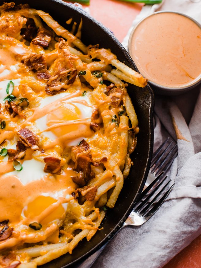 These loaded breakfast fries are topped with everything dreams are made of, bacon cheese, green onion, sunny side up eggs and a spicy aioli!