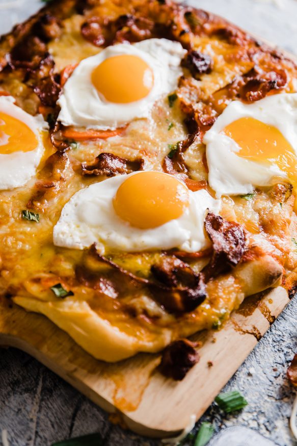 A delicious breakfast pizza loaded with bacon sausage, onion and red bell pepper, then topped with sunny side up eggs. Great weekend breakfast or a breakfast for dinner meal! 