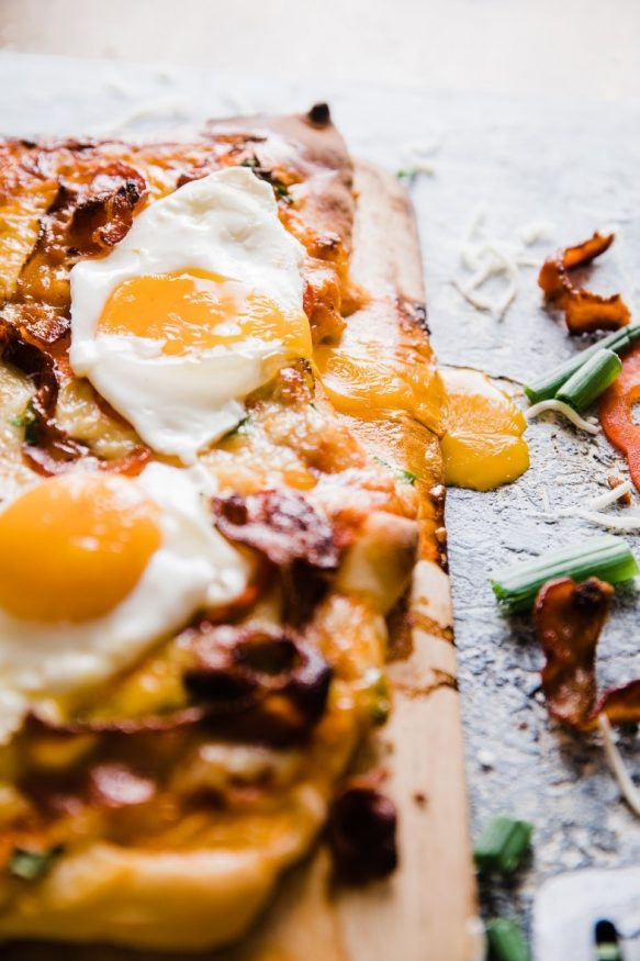 A delicious breakfast pizza loaded with bacon sausage, onion and red bell pepper, then topped with sunny side up eggs. Great weekend breakfast or a breakfast for dinner meal! 