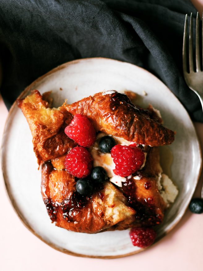 This cream cheese croissant french toast bake is topped with raspberry jam and served with fresh fruit. Can be prepped overnight and bakes in under an hour!