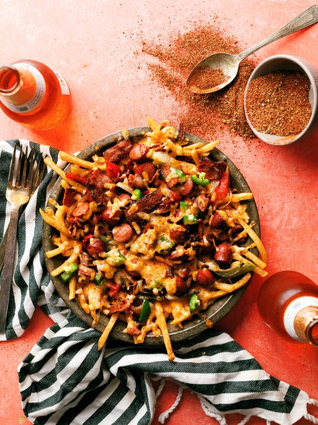 LA Street Meat Cheese fries are topped with cheese, hot dog, peppers and onion, and a spicy fry seasoning that is out of this world. You need to try this!