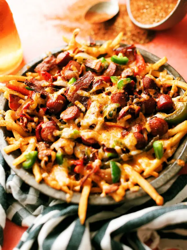 LA Street Meat Cheese fries are topped with cheese, hot dog, peppers and onion, and a spicy fry seasoning that is out of this world. You need to try this!