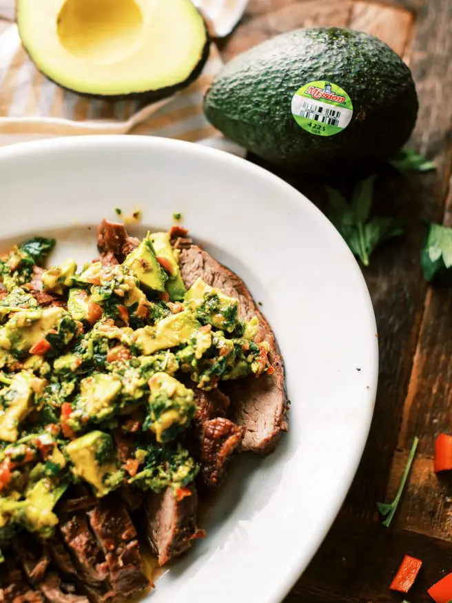 Grilled Flank Steak topped with an avocado chimichurri. This is an amazing summer grilled dinner that is fully of flavor!