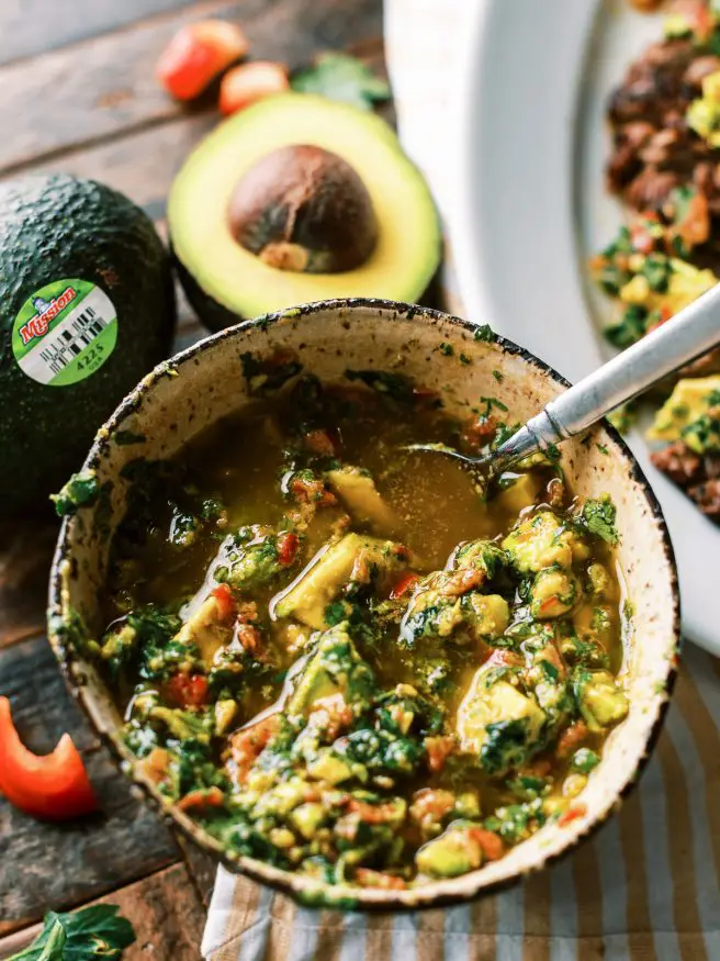 Grilled Flank Steak topped with an avocado chimichurri. This is an amazing summer grilled dinner that is fully of flavor!