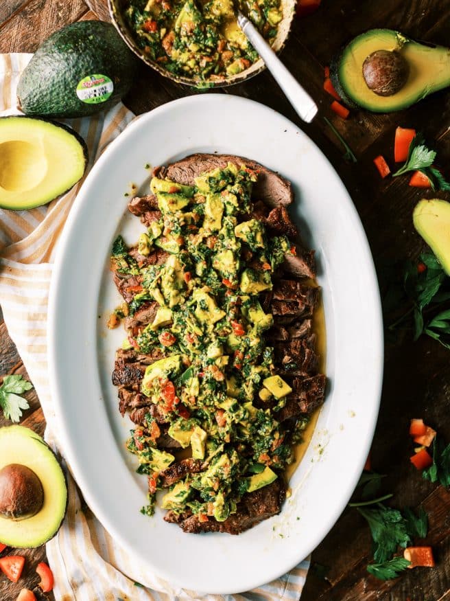 Grilled Flank Steak topped with an avocado chimichurri. This is an amazing summer grilled dinner that is fully of flavor!