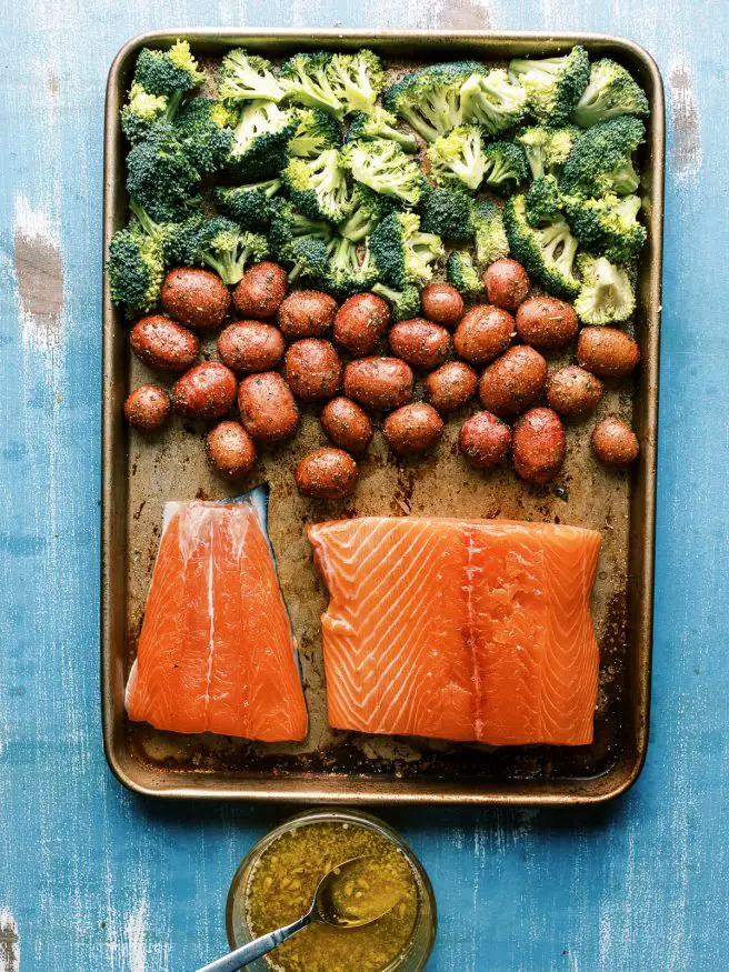 Easy weeknight Sheet Pan recipe with salmon glazed with a lemony honey butter garlic sauce served with baby red potatoes and broccoli. It's easy and a well rounded meal!