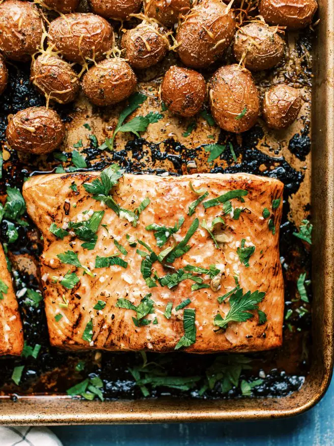 Easy weeknight Sheet Pan recipe with salmon glazed with a lemony honey butter garlic sauce served with baby red potatoes and broccoli. It's easy and a well rounded meal!