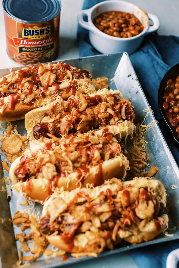 Bacon Wrapped Cowboy Hot dogs with BBQ sauce cheese and some fried onions is a great weeknight dinner paired with some homestyle baked beans