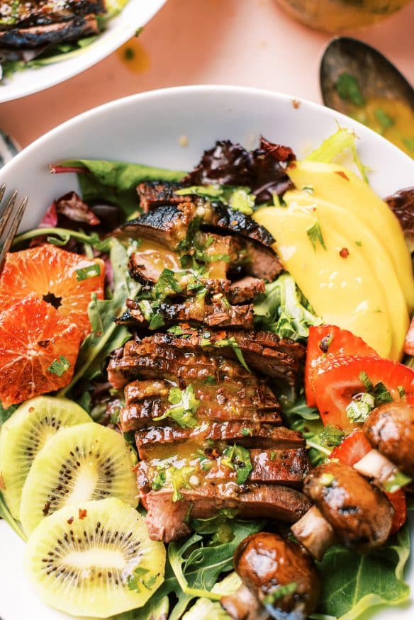 This grilled flank steak summer salad with mango vinaigrette topped with fresh summer fruit for a little sweet, savory and tangy flavors. 