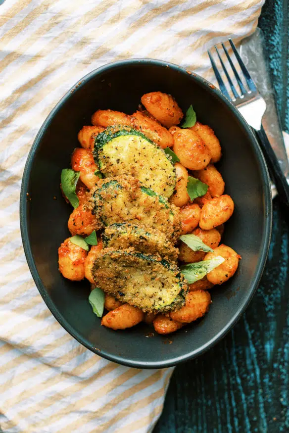 Panko breaded fried zucchini is a great way to inject some veggies into pasta night. Italian seasoned and lightly fried then topped on some gnocchi is perfect!