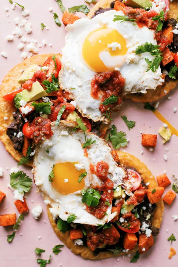 Huevos Rancheros Tostadas with some seasoned sweet potatoes on top makes the perfect breakfast, or breakfast for dinner recipe! 