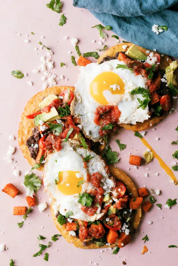 Huevos Rancheros Tostadas with some seasoned sweet potatoes on top makes the perfect breakfast, or breakfast for dinner recipe! 