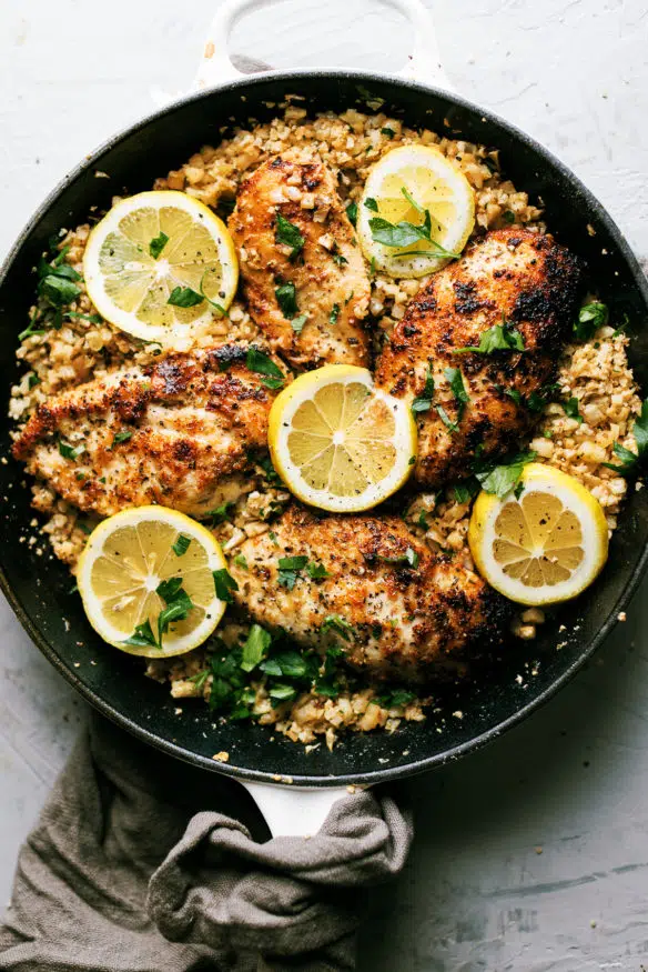 Chicken breast dredged in parmesan and pork rind panko in Italian seasonings sauteed in garlic and butter, topped on some cauliflower rice with some Italian parsley to finish.  