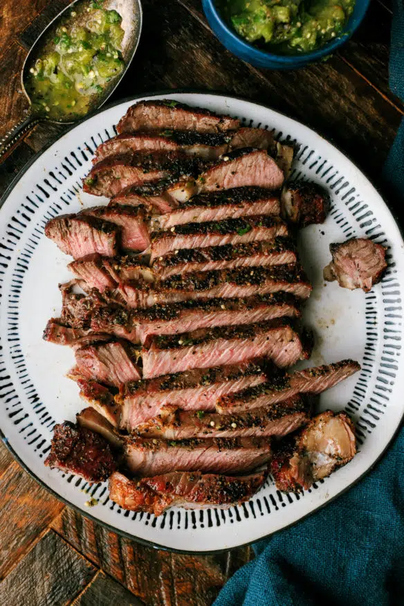 This grilled Ribeye steak is smothered with a spicy and zesty hatch chili verde sauce. It's the perfect combo heading into grilling season!