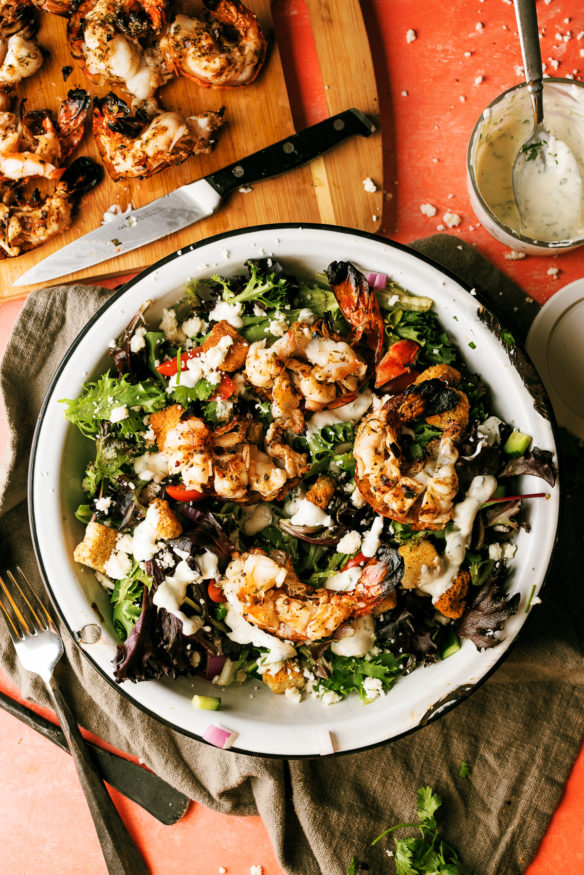 Grilled colossal shrimp salad - marinated shrimp in a butter garlic herb sauce in a fresh summer salad with a cilantro lime ranch dressing.