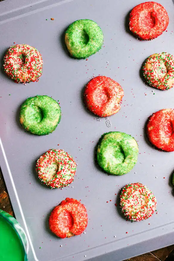 These crunchy thumbprint cookies with a hint of almond flavor are rolled in holiday sprinkles then filled with a little royal icing.