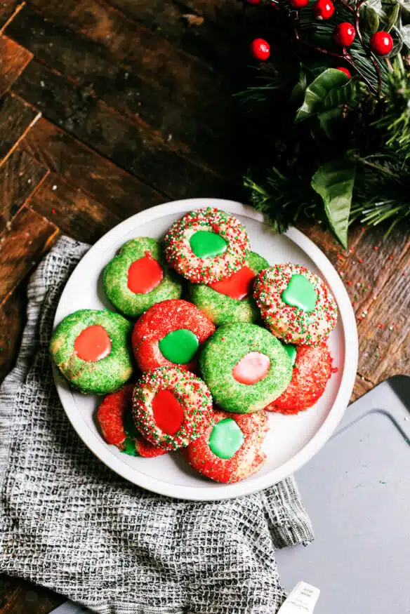 These crunchy thumbprint cookies with a hint of almond flavor are rolled in holiday sprinkles then filled with a little royal icing.