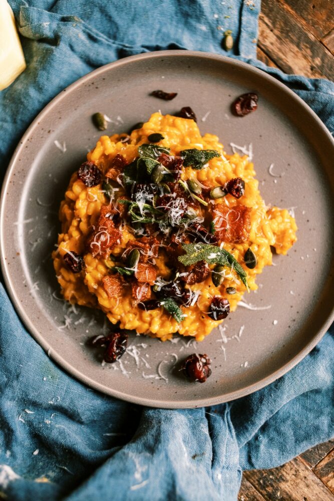 This Creamy Pumpkin Risotto is a fall must! loaded with bacon, parmesan and topped with crispy sage, pumpkin seeds and dried cranberries