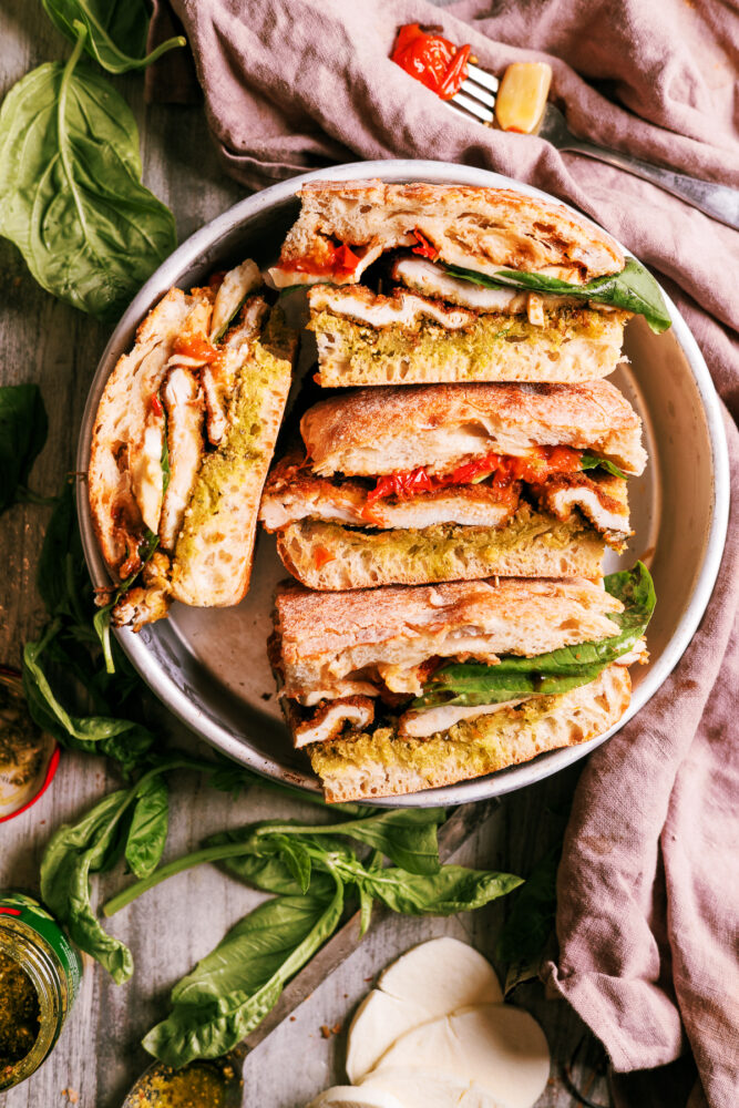 Crispy chicken Caprese sandwich with pesto, roasted tomatoes, fresh mozzarella, and balsamic glaze on toasted ciabatta bread.